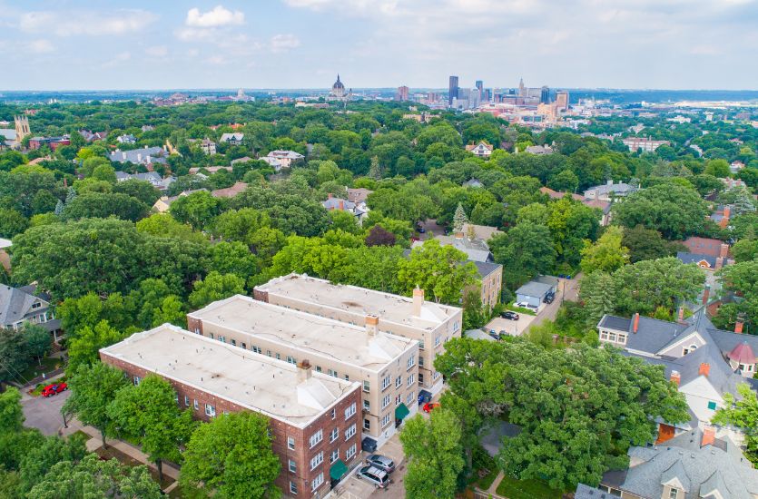 Birdseye view of historic Saint Paul, Minnesota featuring great greenery and brownstone apartments with the city skyline in the distance